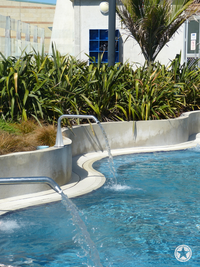 Lounging pool with low pressure water spouts